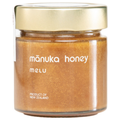 Jar of manuka honey with a gold lid on a white background